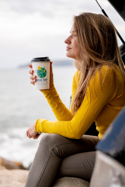 Reisender, der eine nachgemachte Tasse Kaffee hält