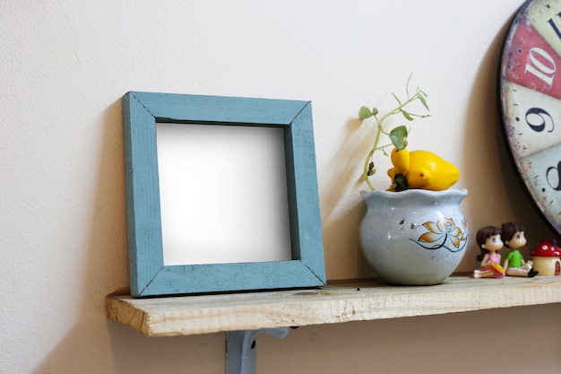 Retro-Vintage-Quadratrahmen auf Bücherregalen mit Mini-Vase- und Pflanzenholzrahmenmodellen