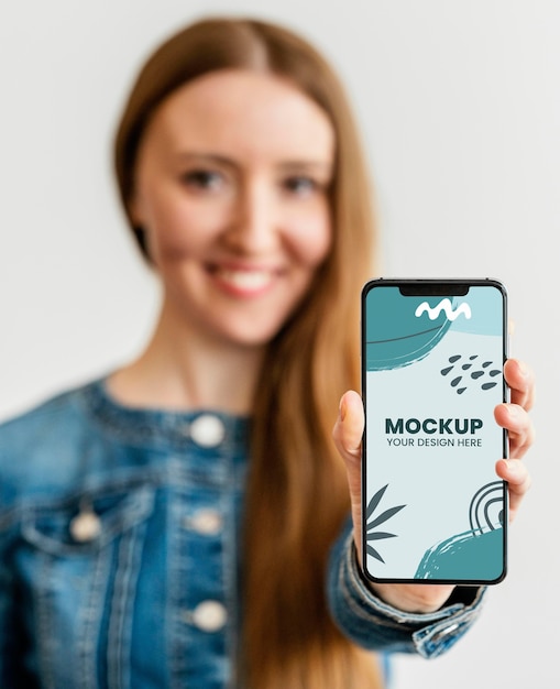 Ritratto di donna in possesso di uno smartphone mock-up