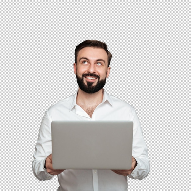 Ritratto di un uomo barbuto sorridente che tiene in mano un computer personale d'argento e guarda verso l'alto isolato su una parete grigio scuro