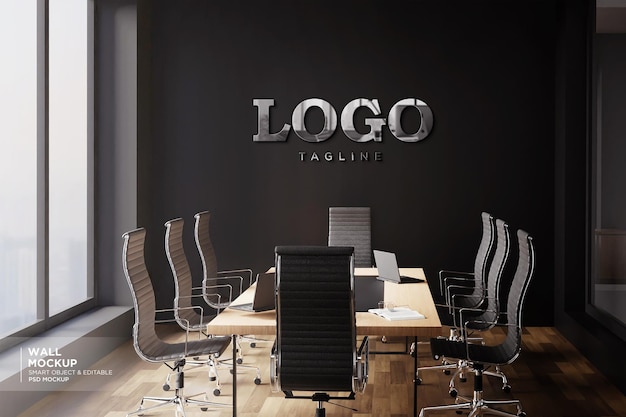 una sala de conferencias con sillas y una pared negra con un modelo de logotipo 3D plateado
