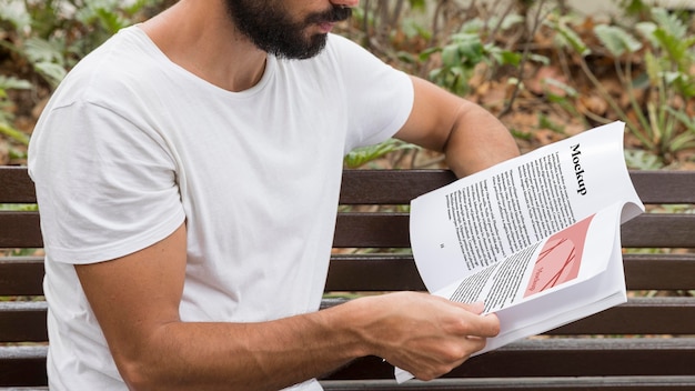 Schließen sie herauf mann auf straße, die buch liest