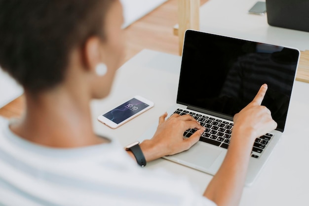 Schwarze Dame arbeitet an einem Laptop in ihrem Büro