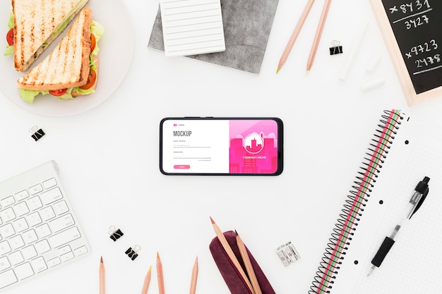 Scrivania vista dall'alto con sandwich e telefono mock-up