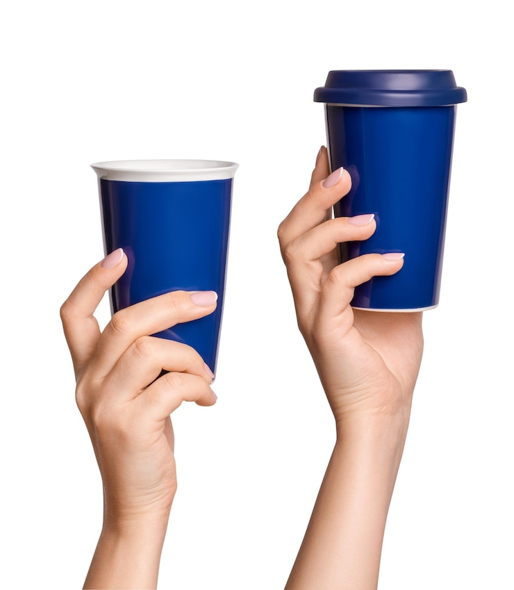 PSD setmano femenina sosteniendo una taza térmica de color azul sobre un fondo en blanco
