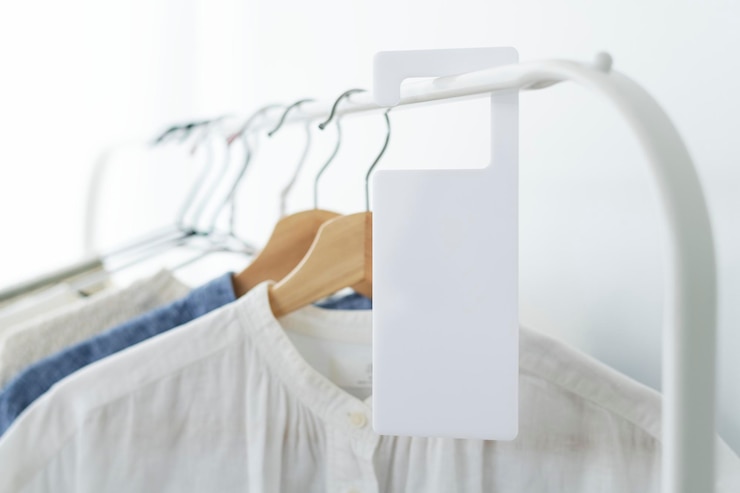 PSD shirts on a clothing rack with a tag mockup in a studio