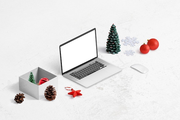 Shopping online per il concetto di regali di Natale. Mockup di laptop, confezione regalo e decorazioni accanto.