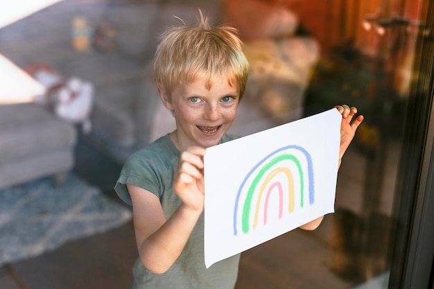 Sign mockup psd boy che mostra carta attraverso la finestra di vetro immagine arcobaleno