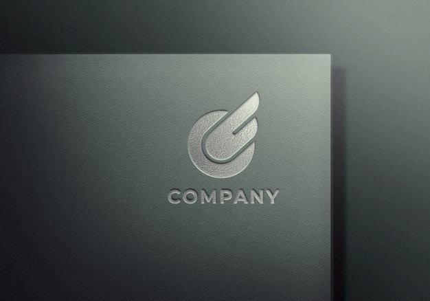 Silber geprägtes Logo-Modell auf grau strukturiertem Papier