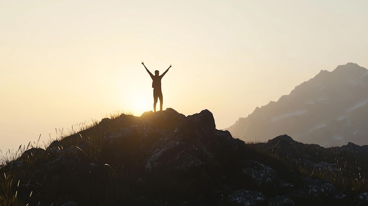 PSD silhouette d'une personne célébrant un lever de soleil au sommet d'une montagne