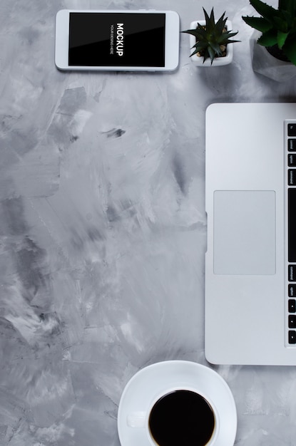 PSD smartphone blanc avec écran blanc noir sur le bureau avec ordinateur portable et tasse de café