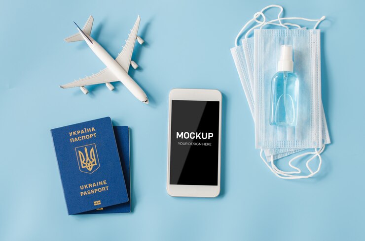 Smartphone com modelo de avião, passaporte, máscara facial e desinfetante