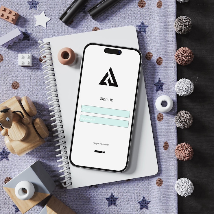 PSD smartphone con interfaccia di iscrizione su una scrivania con giocattoli e notebook