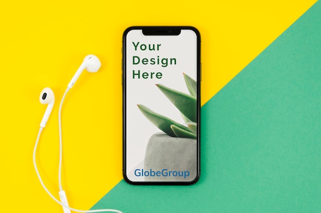 Smartphone e auricolari su superficie gialla e verde