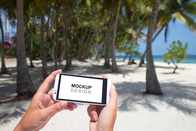 PSD smartphone mock-up com mãos dadas, praia, palmas das mãos