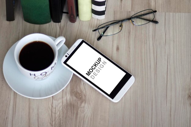 Smartphone mock-up con notebook, caffè, biblioteca, occhiali