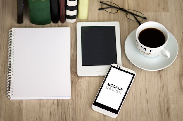 Smartphone-Modell mit Notebook, Kaffee, Brille und Bibliothek