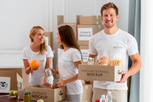 PSD smiley bénévoles préparant des boîtes de provisions pour un don