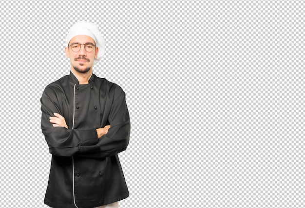 Soddisfatto giovane chef con le braccia incrociate gesto