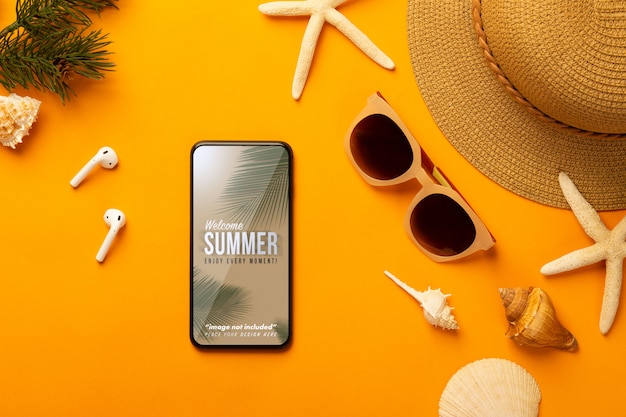 Sommerhintergrund mit Telefonmodellschablone und Strandzubehör auf leuchtendem Orange