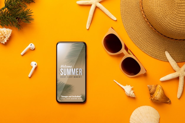 Sommerhintergrund mit telefonmodellschablone und strandzubehör auf leuchtendem orange