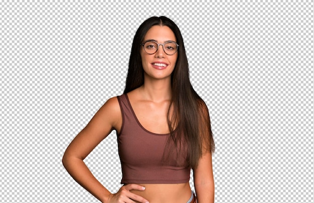 Sonriendo felizmente con una mano en la cadera y con confianza positiva actitud orgullosa y amistosa