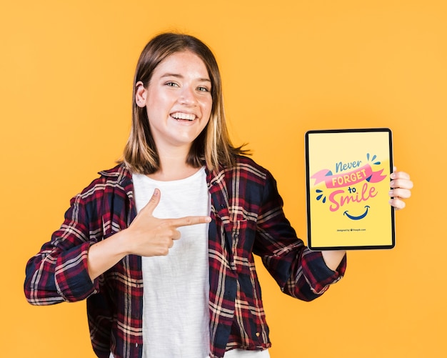 Sonriente joven dedo acusador en una maqueta de tableta