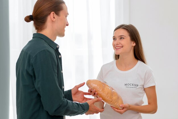 PSD sorridente voluntária distribuindo pão ao homem