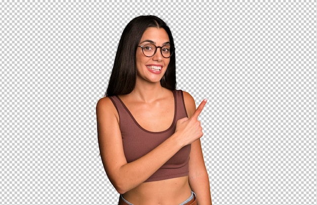 Sorrindo alegremente sentindo-se feliz e apontando para o lado e para cima mostrando o objeto no espaço de cópia