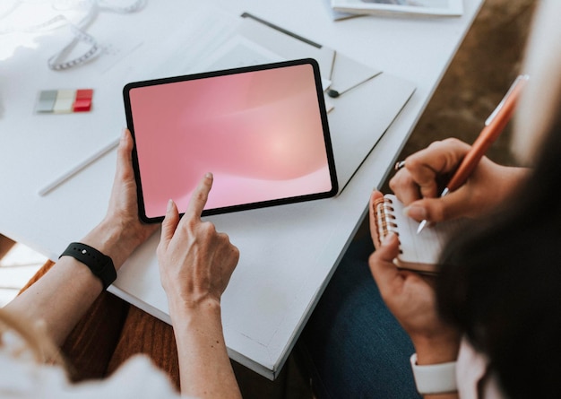 Stilista di moda che prende appunti da un mockup di tablet digitale