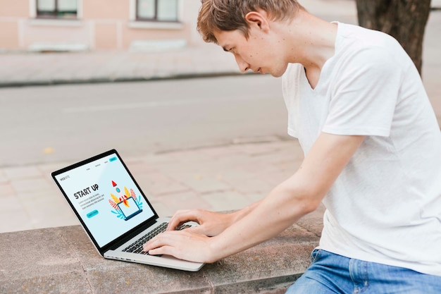 Studente che lavora al computer portatile all'aperto