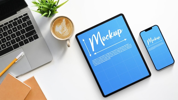 Tablet su un tavolo con un laptop e un caffè sopra