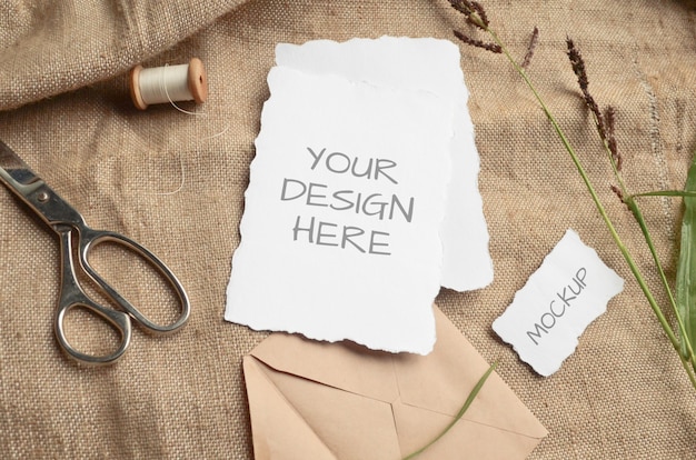 Tarjeta de felicitación de tarjeta de maqueta o invitación de boda con bordes dentados con hierbas, carrete vintage en un espacio beige de tela de arpillera