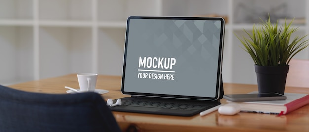 Tavolo da lavoro con mockup di tavoletta digitale, libro e accessori