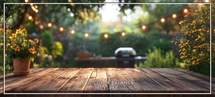 Tavolo di legno con sfondo sfocato di un giardino con luci a corda e una griglia