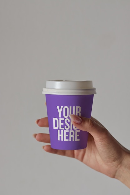 Taza de café púrpura en maqueta de mano diseño personalizado primer plano de color cambiable