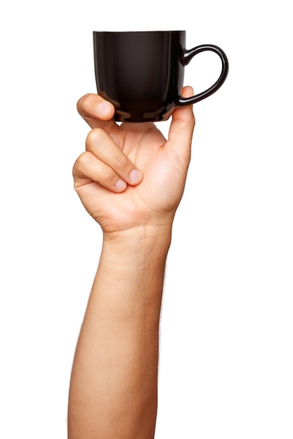 Taza negra en la mano de un hombre sobre un fondo vacío