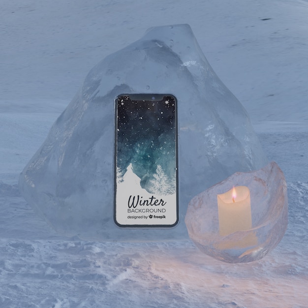 Teléfono en bloque de hielo iluminado por vela