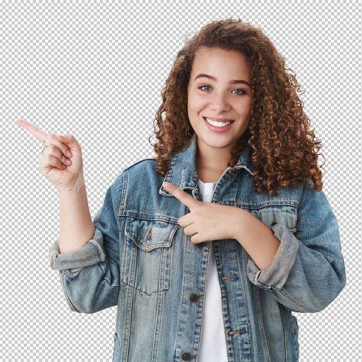 PSD tender femenino joven estudiante rizado peinado apuntando con el dedo índice izquierdo sonriendo amable preguntando qué lugar dormitorio de pie alegre pared blanca