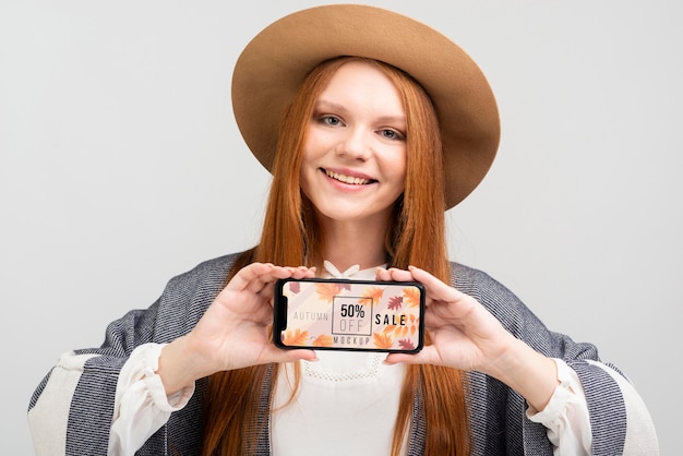 Tiro medio mujer sonriente sosteniendo teléfono