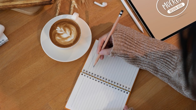 Toma recortada de mujer joven escribiendo en cuaderno en blanco