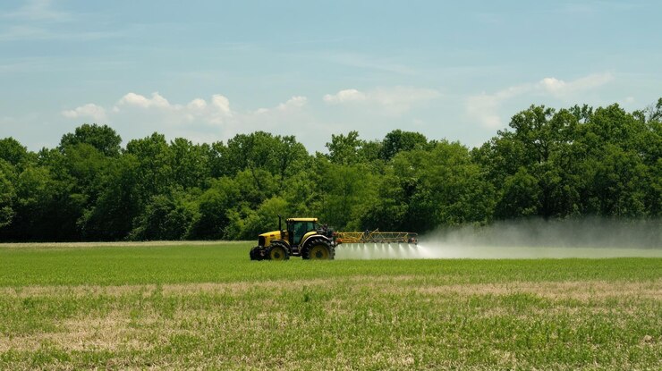 PSD tractor rociando pesticidas en un campo verde