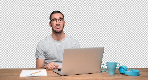 Triste joven sentado en su escritorio