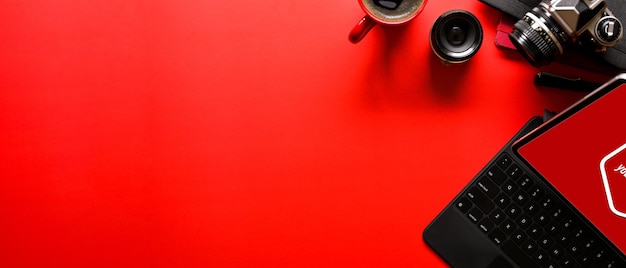 Überkopfaufnahme des leuchtend roten Fotografentischs mit Büromaterial