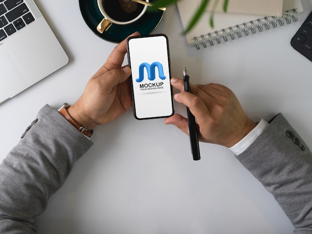 PSD Überkopfaufnahme von männlichen unternehmerhänden unter verwendung des modell-smartphones