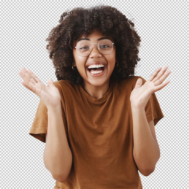 Überrascht, spielerisch und berührt, gut aussehende afroamerikanische Frau in Brille und stilvollem braunen T-Shirt, die sich die Hände schließt und vor Freude und Aufregung lächelt, die große Show mag