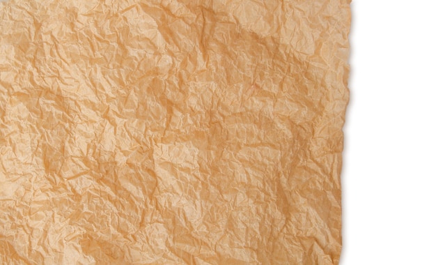 PSD um pedaço rasgado de papel de artesanato amassado sobre um fundo em branco.