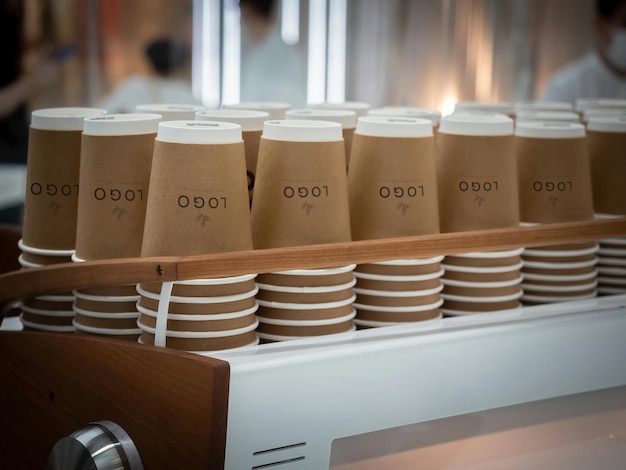 uma fila de copos de café estão empilhados em uma prateleira