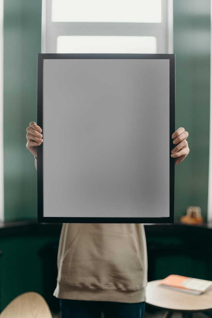 PSD una persona che tiene una foto incorniciata in nero che dice "quote blank"