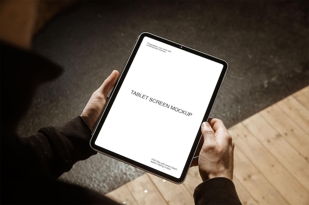 Una persona in possesso di un tablet con mockup dello schermo